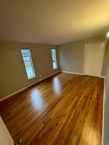 an empty room with wooden floor and closet