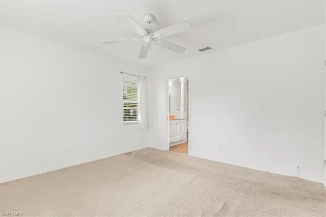 an empty room with a ceiling fan and a window