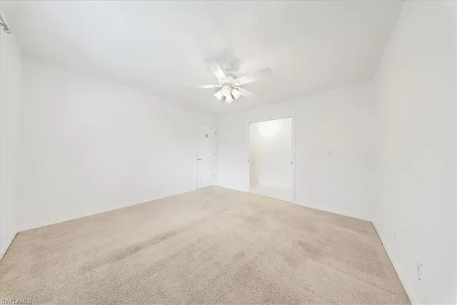 an empty room with a ceiling fan and a window