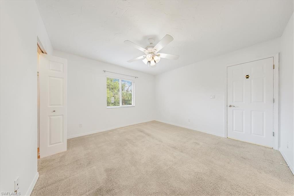 230 Timber Lake Circle, Unit C204 Naples, FL 34104 - Photo 19 of 30 an empty room with a ceiling fan and a window