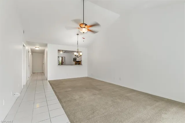 a view of a room with a chandelier fan and windows