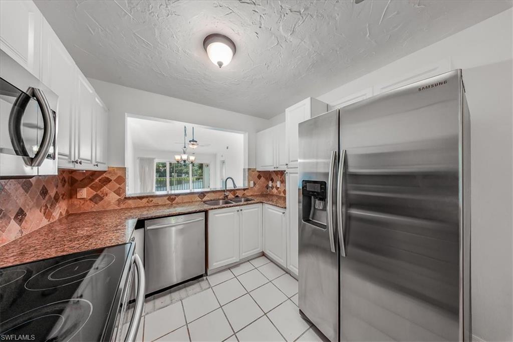 230 Timber Lake Circle, Unit C204 Naples, FL 34104 - Photo 7 of 30 a kitchen with a sink stainless steel appliances and cabinets
