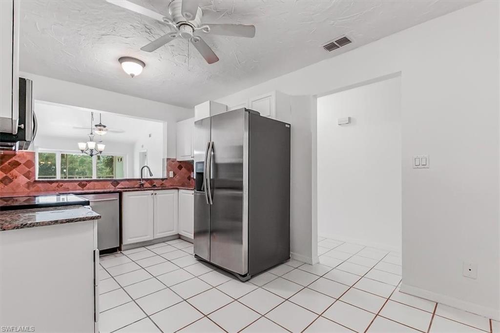 230 Timber Lake Circle, Unit C204 Naples, FL 34104 - Photo 9 of 30 a kitchen with a refrigerator sink and cabinets