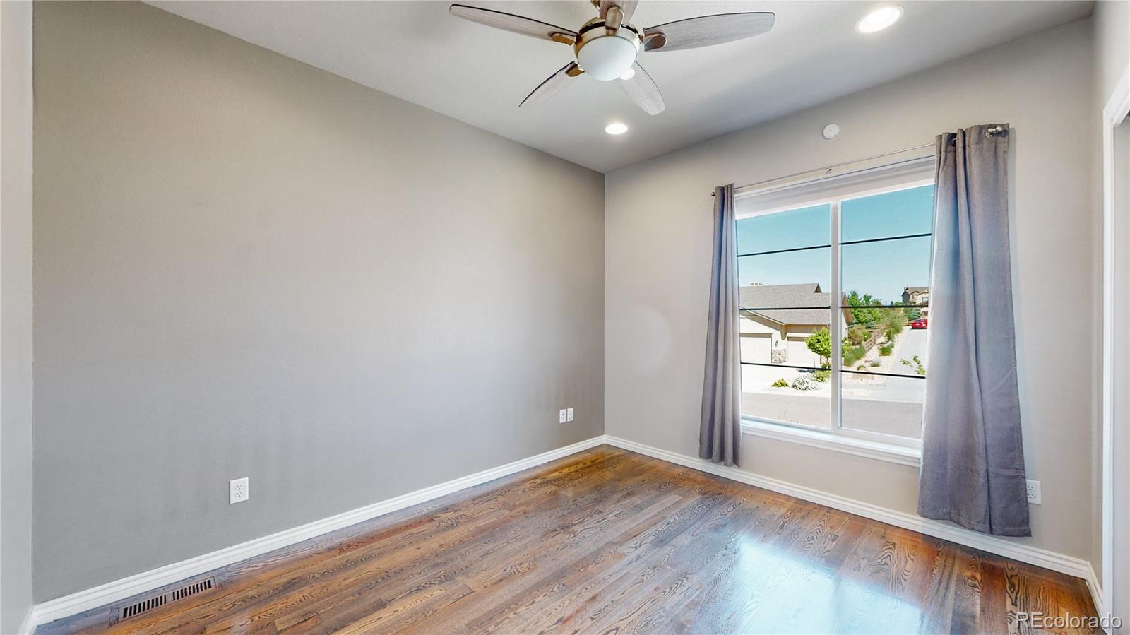 12449 Carmel Ridge Road Colorado Springs, CO 80921 - Photo 14 of 40 wooden floor in an empty room with a window