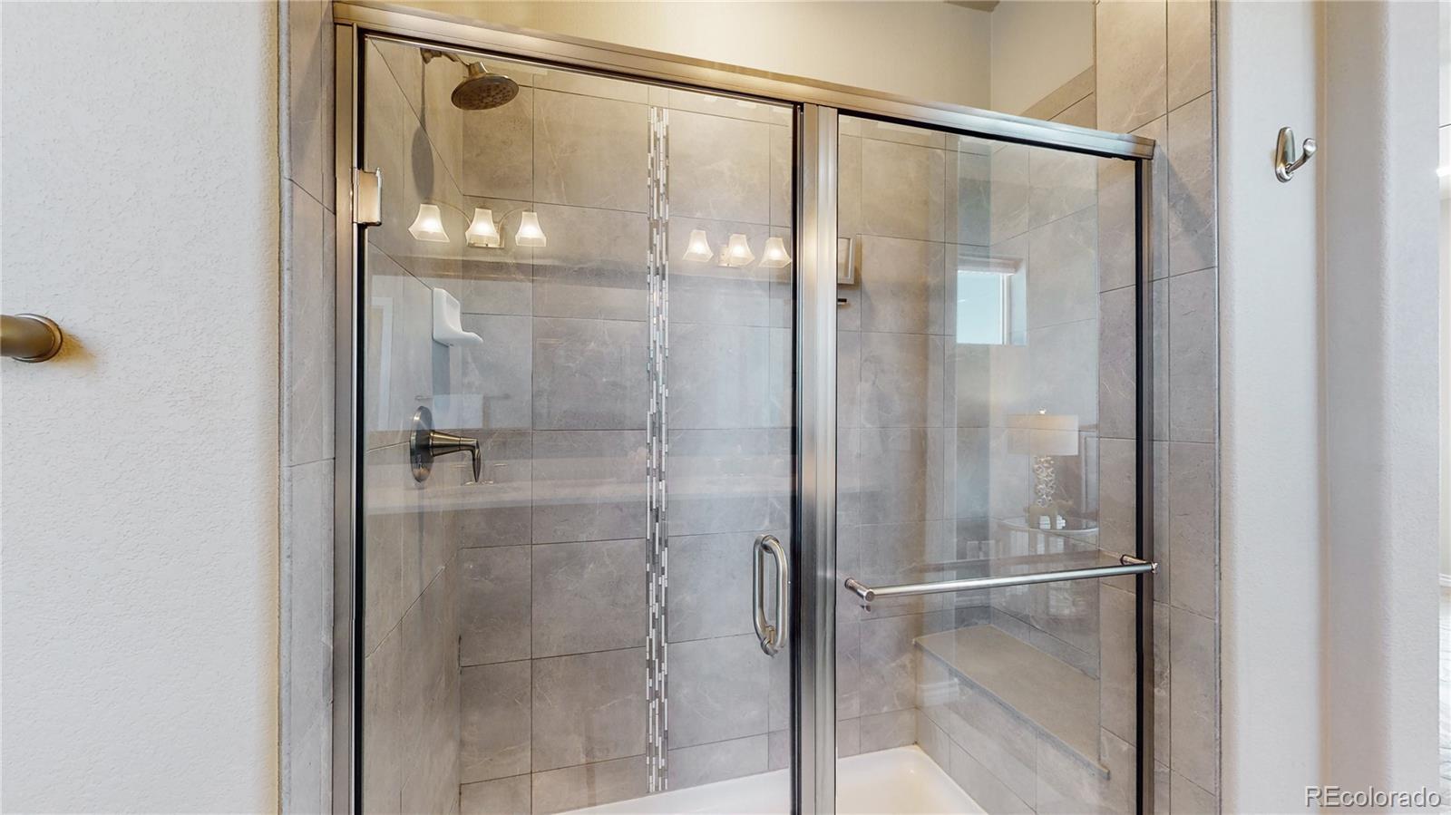12449 Carmel Ridge Road Colorado Springs, CO 80921 - Photo 25 of 40 a bathroom with a glass shower door