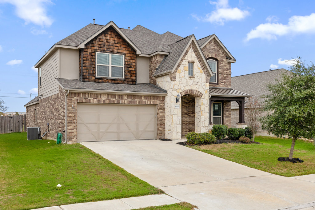 a front view of a house with a yard and garage