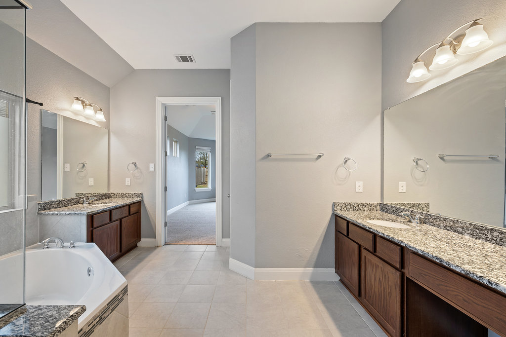 5208 Anaheim Avenue Pflugerville, TX 78660 - Photo 18 of 38 a spacious bathroom with a granite countertop tub sink and mirror