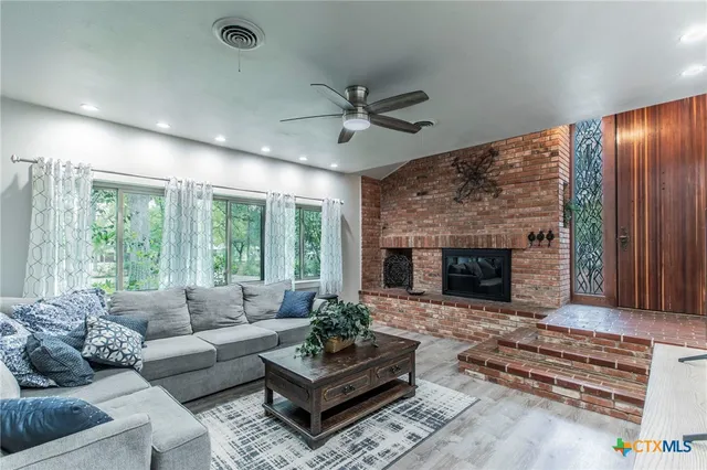 a living room with furniture fireplace and window