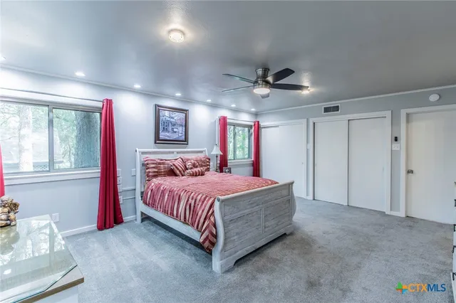 a spacious bedroom with a bed and a chandelier