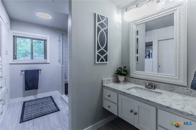 a bathroom with a granite countertop sink and a mirror