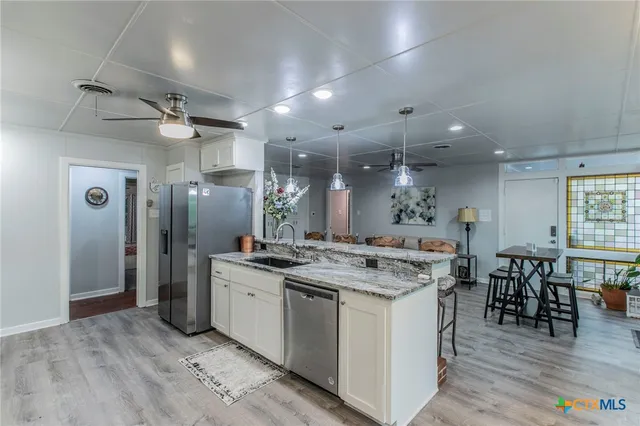 a kitchen that has a stove a table and chairs in it