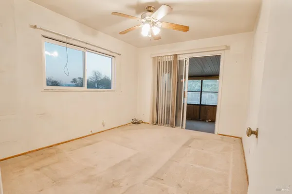 a view of a room with a ceiling fan and a window