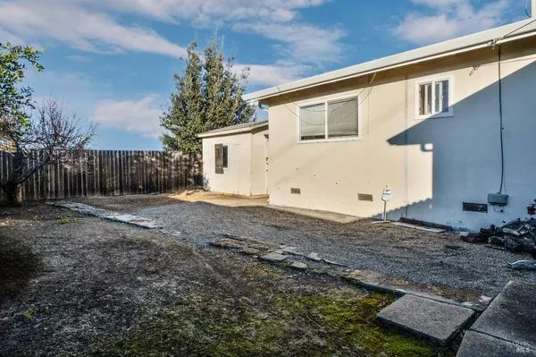 a view of a house with backyard and trees