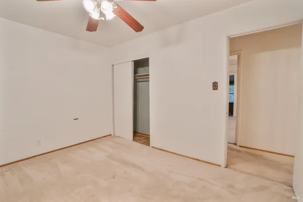 an empty room with a empty space and a ceiling fan