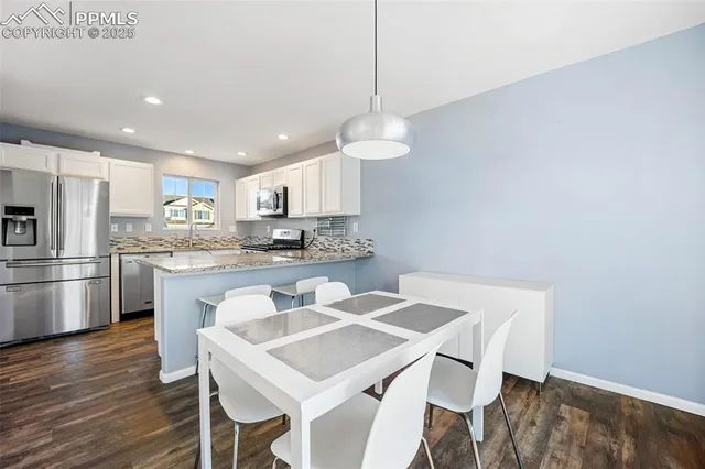 a kitchen with kitchen island a stove a table and chairs