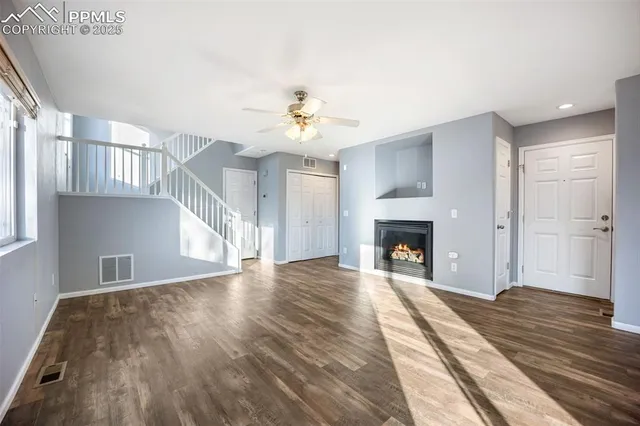 a view of an empty room window and wooden floor