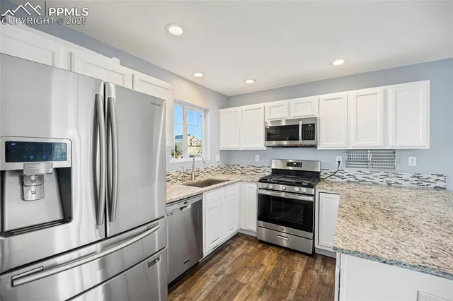 a kitchen with stainless steel appliances granite countertop a refrigerator stove and microwave