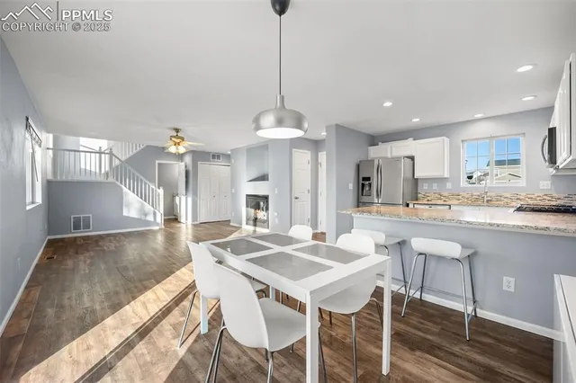 a kitchen with granite countertop kitchen island stainless steel appliances a dining table and chairs