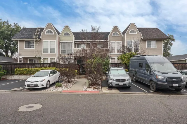 a front view of a house with cars parked