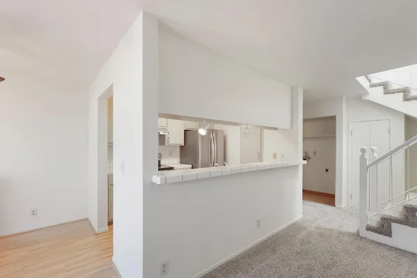 a view of a kitchen with white cabinets and wooden floor