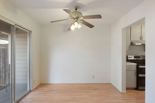 a view of an empty room and kitchen view