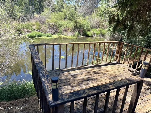 a view of a balcony with wooden floor and fence