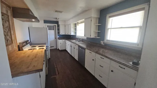 a kitchen with stainless steel appliances granite countertop refrigerator sink and window