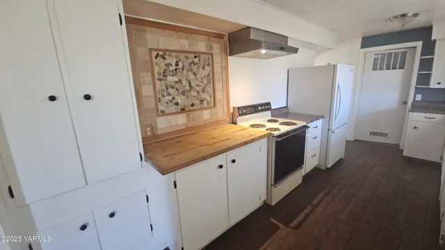 a kitchen with stainless steel appliances granite countertop a refrigerator a stove and a sink