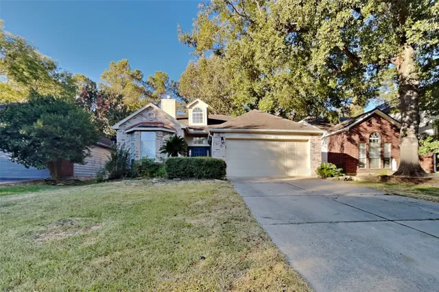 a front view of a house with a garden and tree