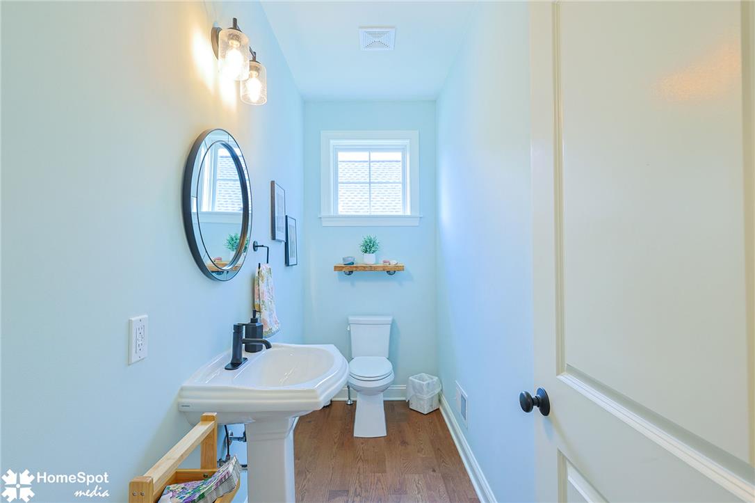 4518 Old Saucon Road Bethlehem, PA 18015 - Photo 16 of 19 A compact powder room with a pedestal sink, framed mirror, and warm lighting.