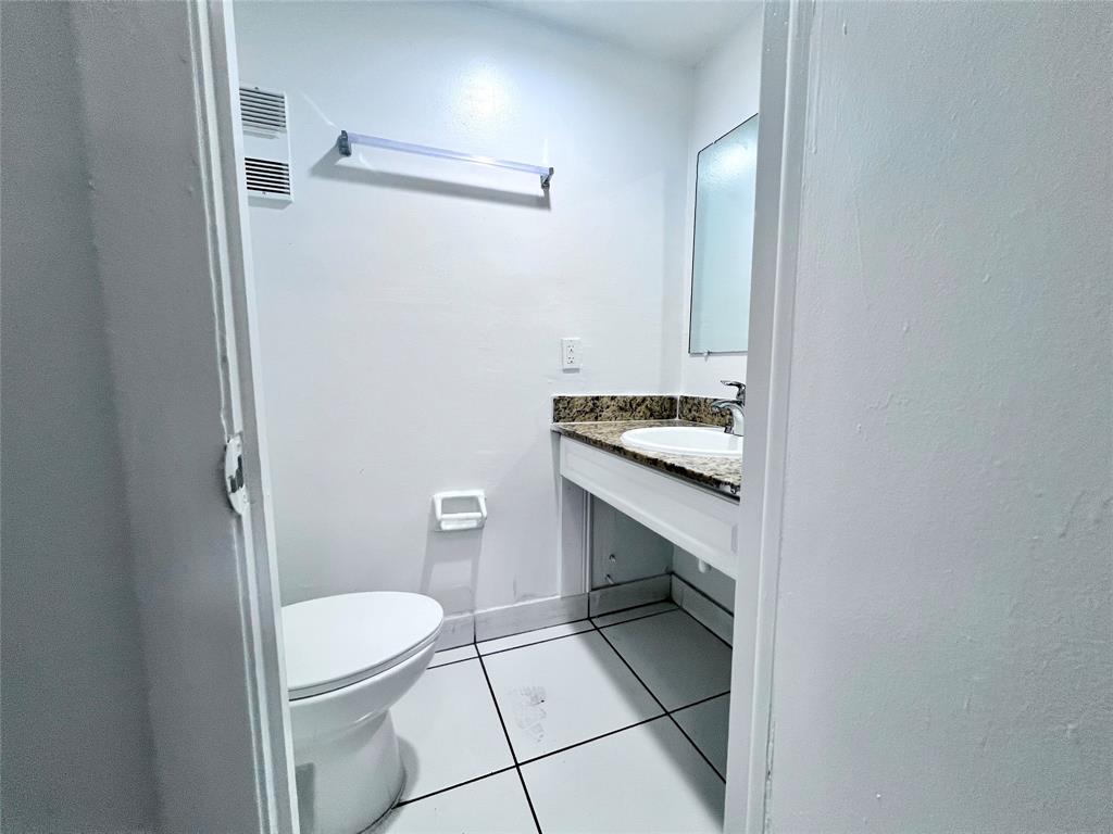 2580 Northwest 56th Avenue, Unit 700420 Lauderhill, FL 33313 - Photo 5 of 16 a bathroom with a granite countertop toilet and a sink