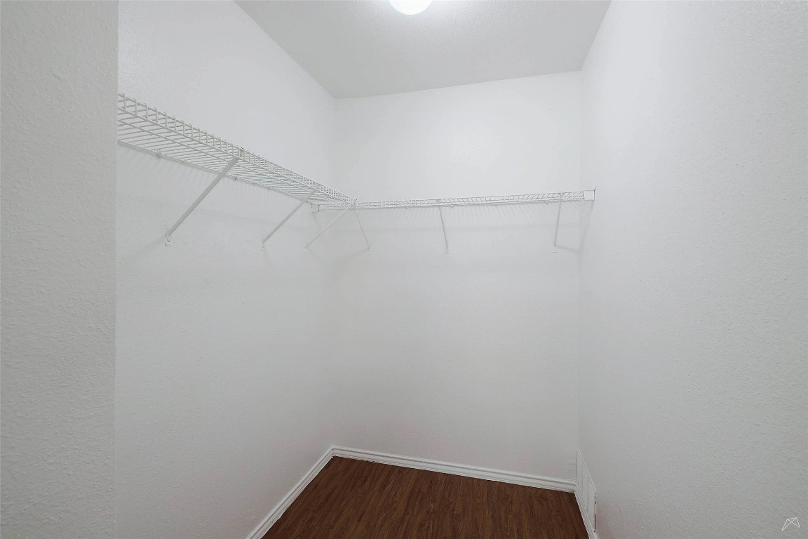 2323 Wells Branch Parkway, Unit C102 Austin, TX 78728 - Photo 11 of 20 Walk in closet featuring dark wood finished floors
