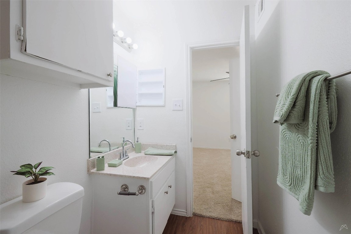 2323 Wells Branch Parkway, Unit C102 Austin, TX 78728 - Photo 13 of 20 Half bath with vanity and dark wood-type flooring
