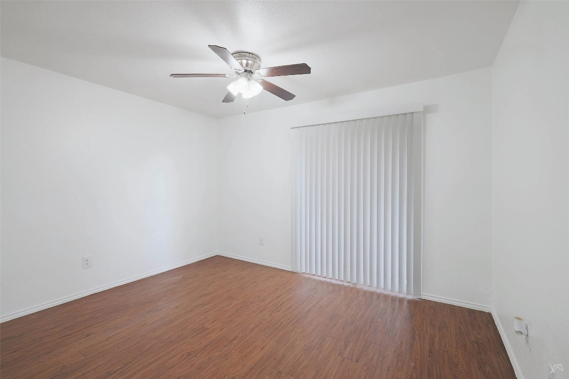 2323 Wells Branch Parkway, Unit C102 Austin, TX 78728 - Photo 3 of 20 Unfurnished room with dark wood-style floors and a ceiling fan