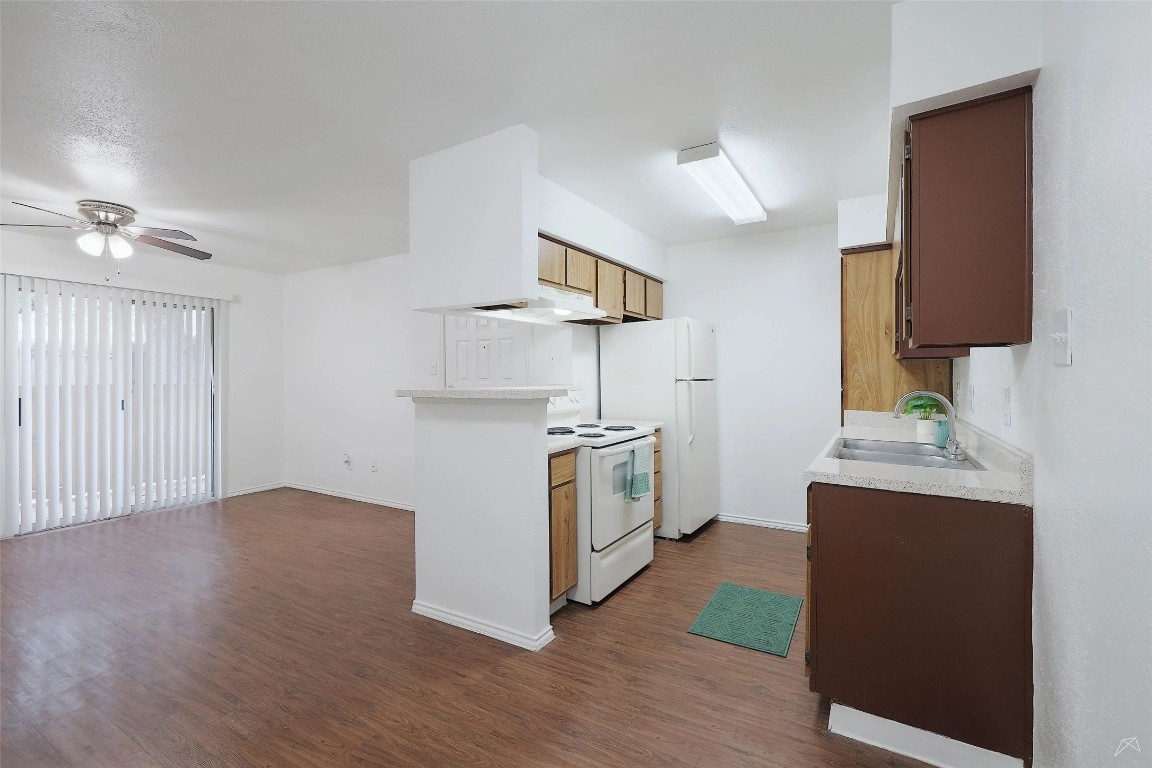 2323 Wells Branch Parkway, Unit C102 Austin, TX 78728 - Photo 6 of 20 Kitchen featuring light countertops, white electric range oven, dark wood finished floors, and ceiling fan