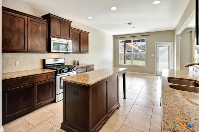 a kitchen with stainless steel appliances granite countertop a stove and a sink