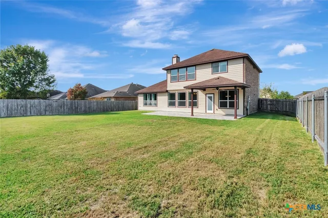 a view of a house with a yard and sitting area