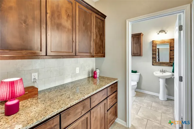a bathroom with a granite countertop sink and a mirror