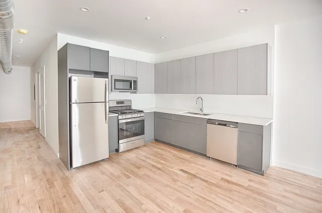a kitchen with white cabinets and white appliances