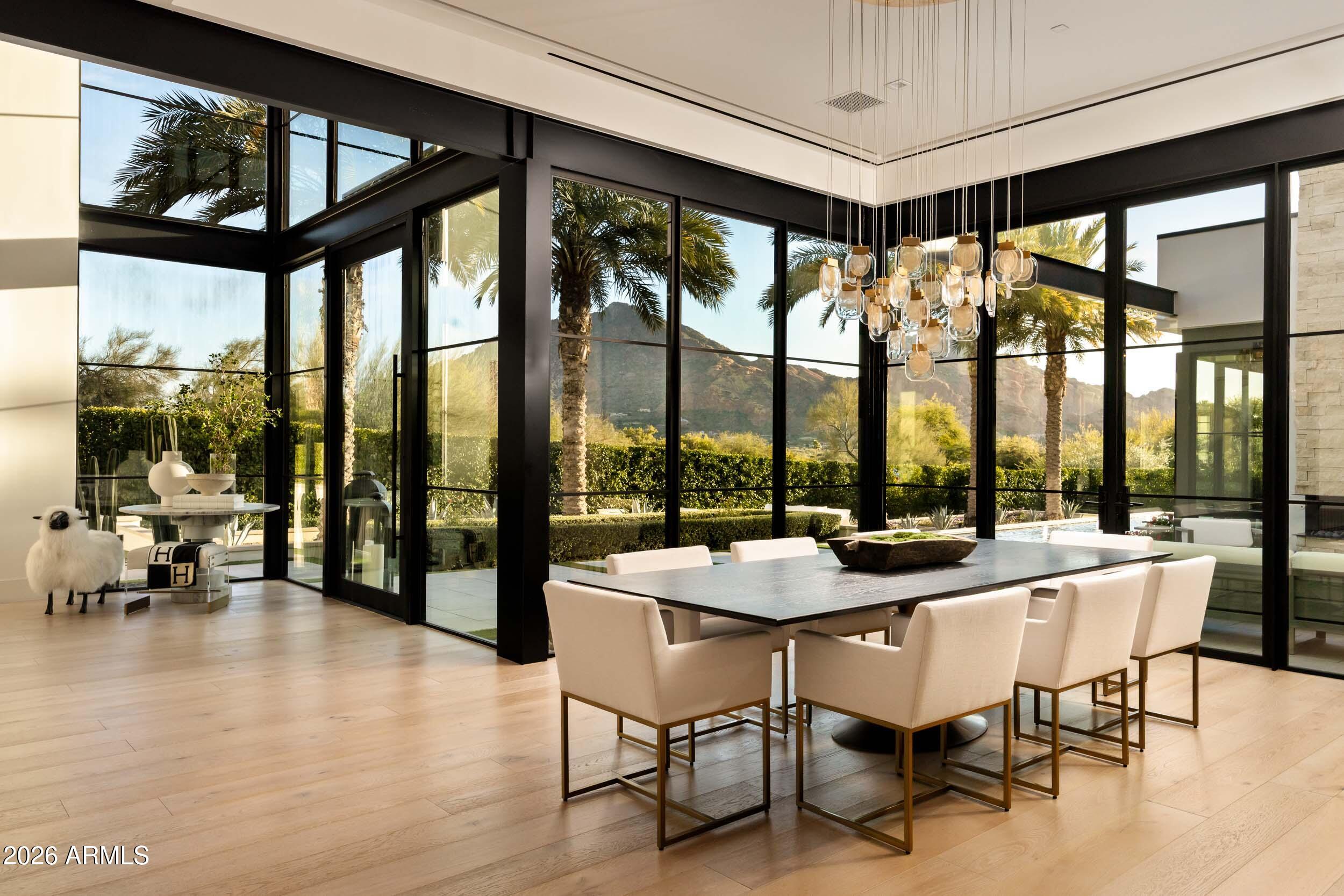 6800 North Mummy Mountain Road Paradise Valley, AZ 85253 - Photo 19 of 61 a dining room with stainless steel appliances granite countertop a table and chairs with wooden floor
