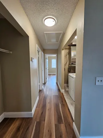 a view of a hallway with wooden floor