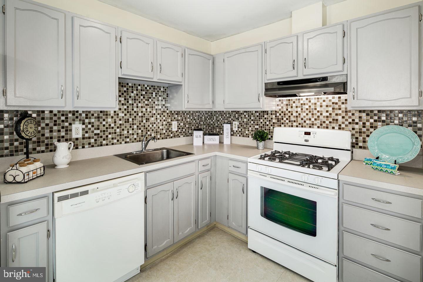 a kitchen with cabinets appliances a sink and a stove