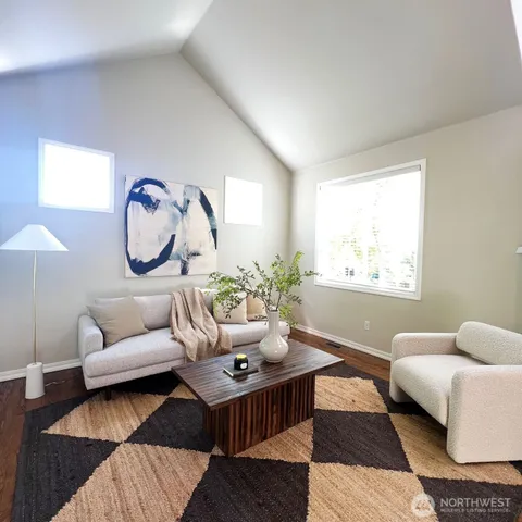 a living room with furniture a rug a lamp and a window