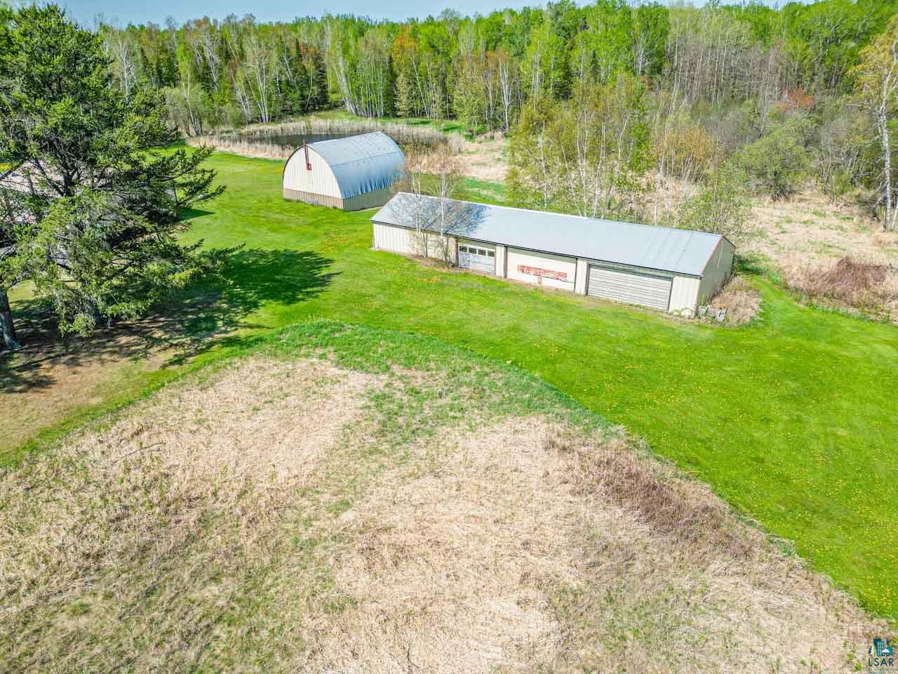 2581 O'Rourke Road Hibbing, MN 55746 - Photo 49 of 61 Expansive property featuring a metal-sided pole barn with multiple garage doors and a separate Quonset hut structure