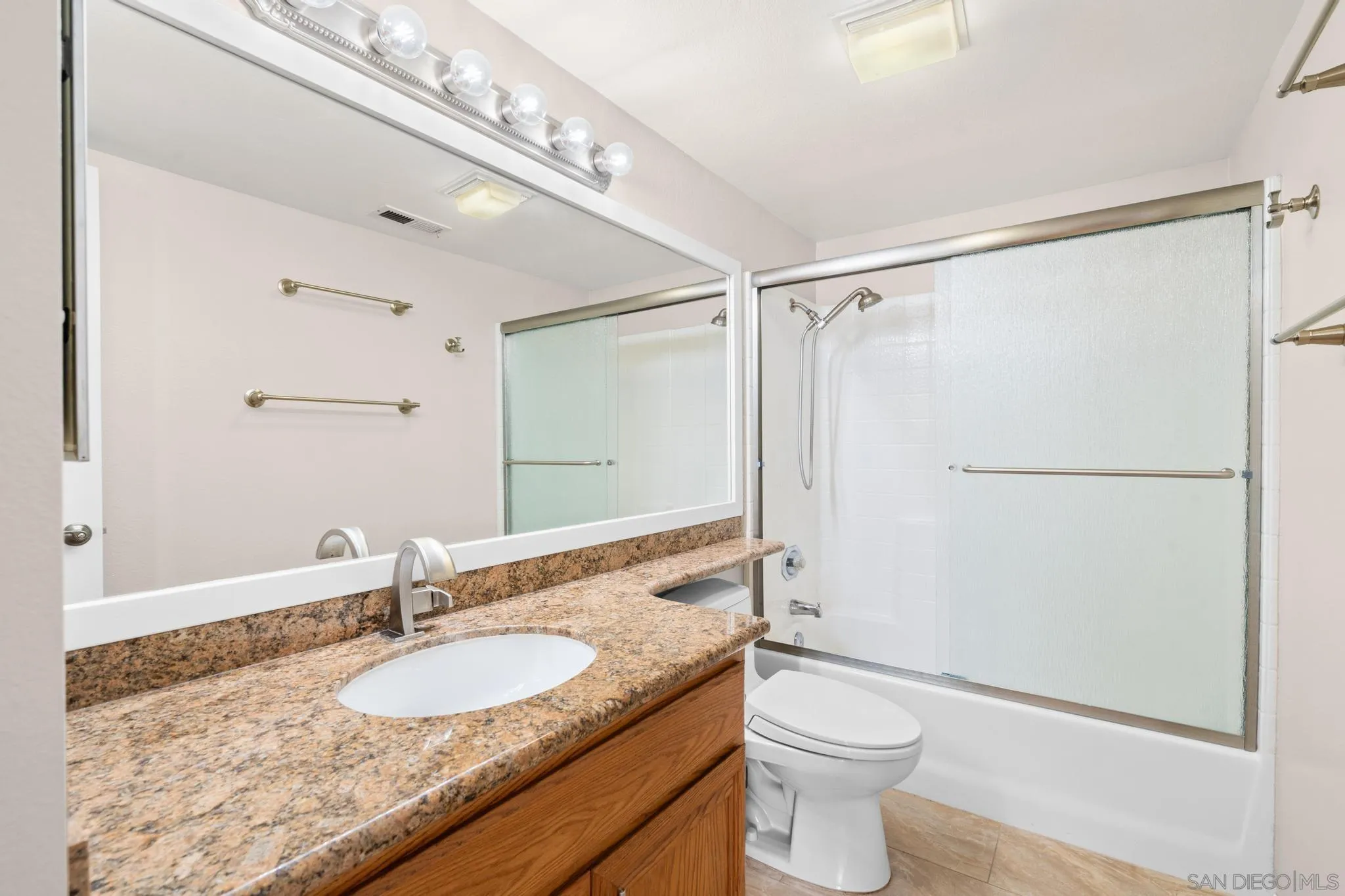 9338 Babauta Road, Unit 78 San Diego, CA 92129 - Photo 15 of 26 a bathroom with a granite countertop sink toilet mirror and a shower