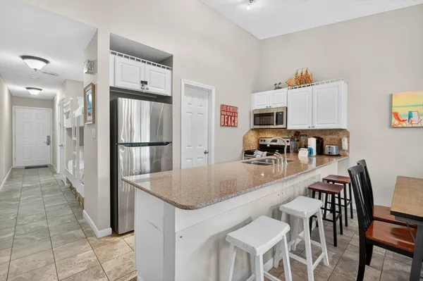 a kitchen with stainless steel appliances granite countertop a refrigerator and a stove top oven