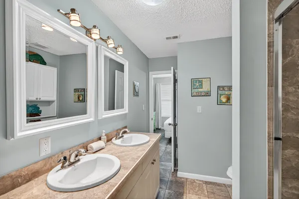 a bathroom with a sink double vanity granite and a mirror