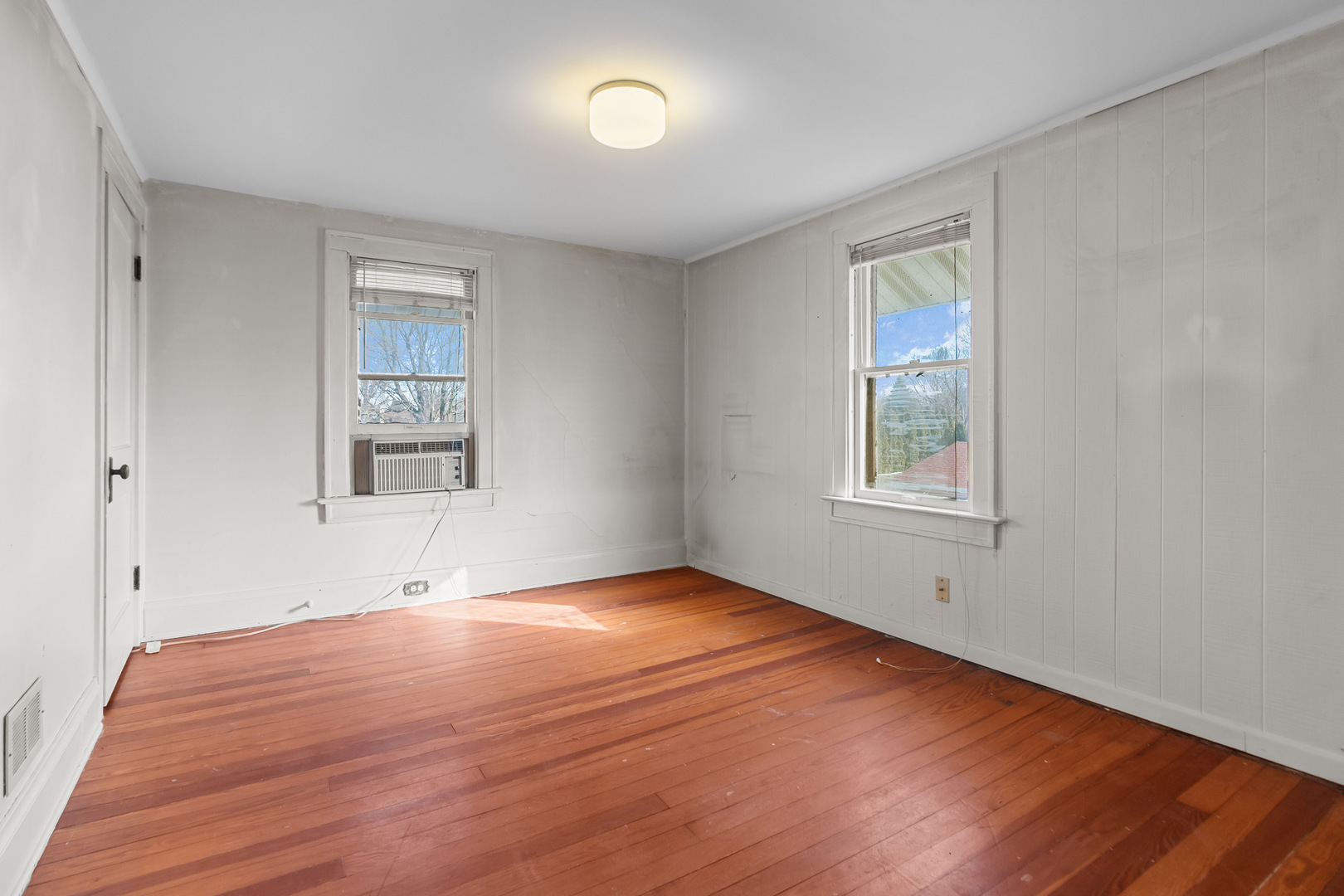 607 West Burbank Street Harvard, IL 60033 - Photo 12 of 22 an empty room with wooden floor and windows