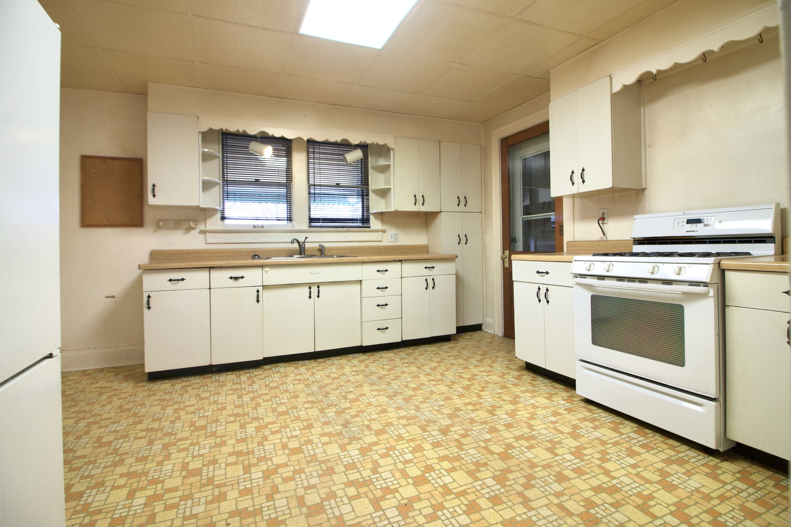607 West Burbank Street Harvard, IL 60033 - Photo 7 of 22 a kitchen with a stove a sink and a refrigerator