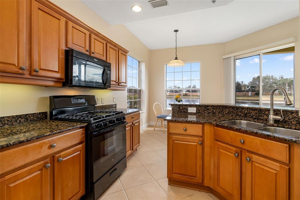 8407 Miramar Way Lakewood Ranch, FL 34202 - Photo 26 of 83 a kitchen with stainless steel appliances granite countertop a stove a sink and a microwave